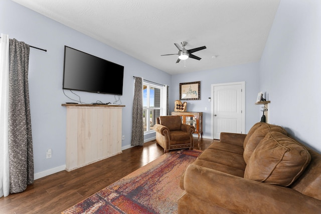 living room featuring ceiling fan, dark hardwood / wood-style floors, and a textured ceiling