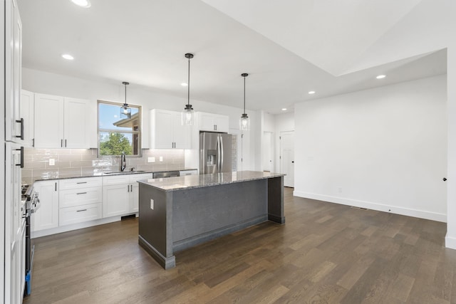 kitchen featuring appliances with stainless steel finishes, sink, a center island, dark hardwood / wood-style floors, and white cabinetry