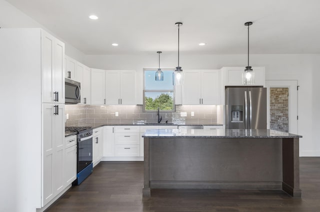 kitchen featuring a center island, white cabinets, decorative light fixtures, dark hardwood / wood-style flooring, and stainless steel appliances