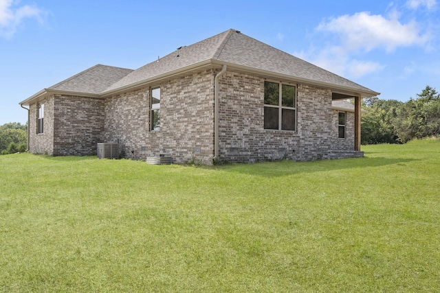 view of side of property with central air condition unit and a lawn