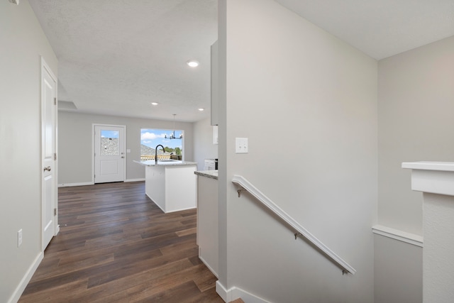 corridor featuring a chandelier, sink, and dark hardwood / wood-style floors