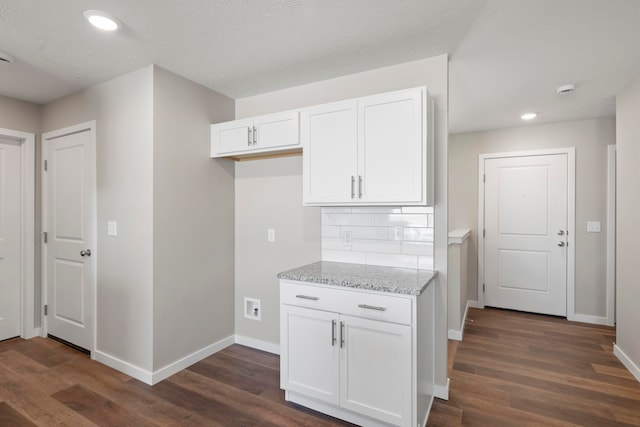 kitchen with light stone counters, white cabinets, a textured ceiling, and dark wood-type flooring