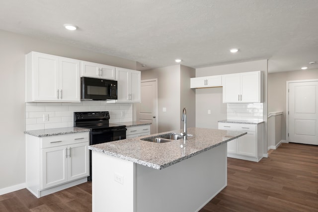 kitchen featuring white cabinets, a kitchen island with sink, dark hardwood / wood-style floors, and black appliances