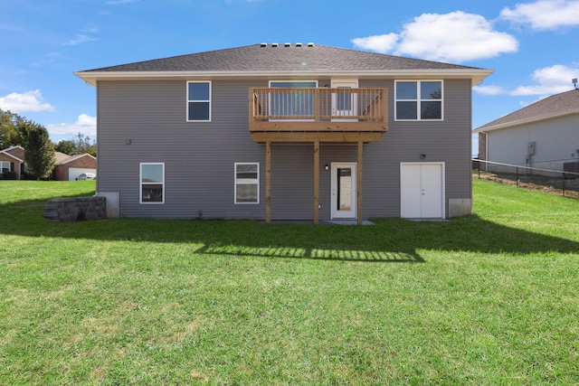 rear view of house with a balcony and a lawn