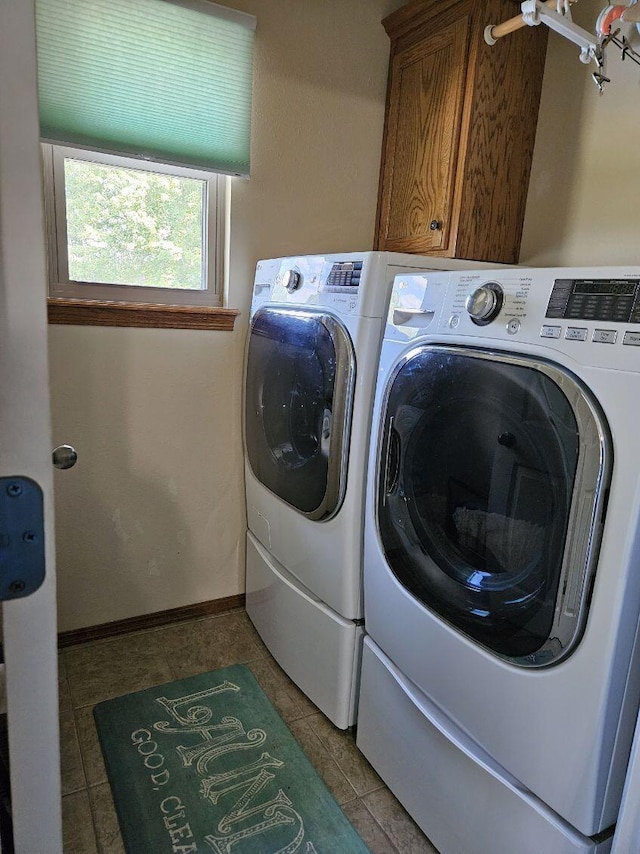 laundry area with washer and dryer, light tile patterned floors, and cabinets