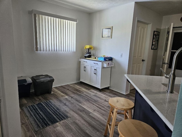 kitchen featuring hardwood / wood-style flooring, white cabinetry, and a textured ceiling