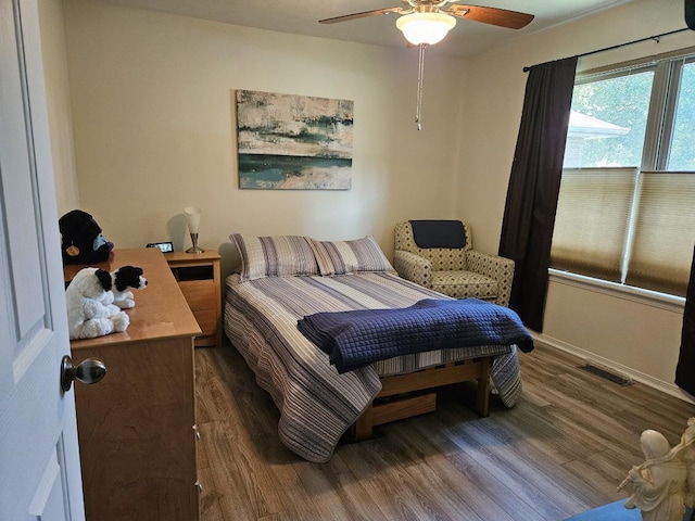 bedroom with ceiling fan and dark wood-type flooring