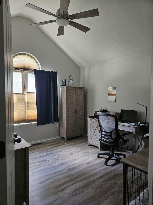 home office with ceiling fan, vaulted ceiling, and hardwood / wood-style floors