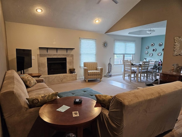 living room with a premium fireplace, vaulted ceiling, and a textured ceiling