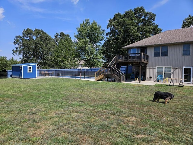 view of yard featuring a storage shed, a patio, and a pool side deck