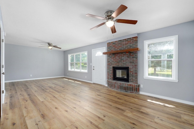 unfurnished living room featuring a fireplace, ceiling fan, and light hardwood / wood-style floors