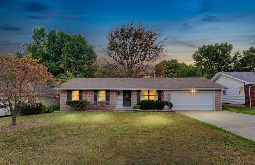 single story home with a yard and a garage