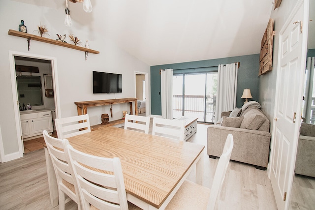 dining area with sink, vaulted ceiling, and light hardwood / wood-style floors