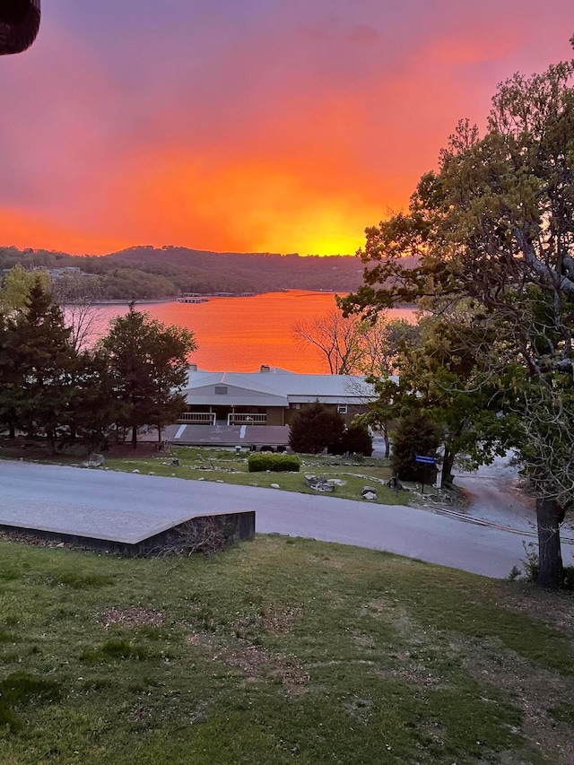 yard at dusk featuring a water view