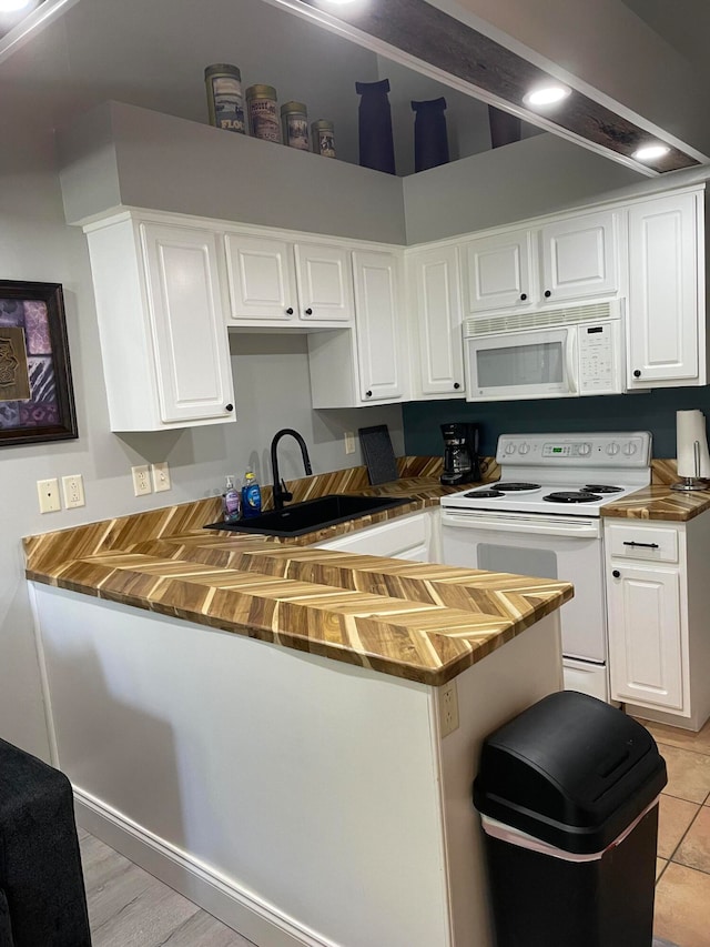 kitchen with sink, wooden counters, white appliances, light hardwood / wood-style flooring, and white cabinetry