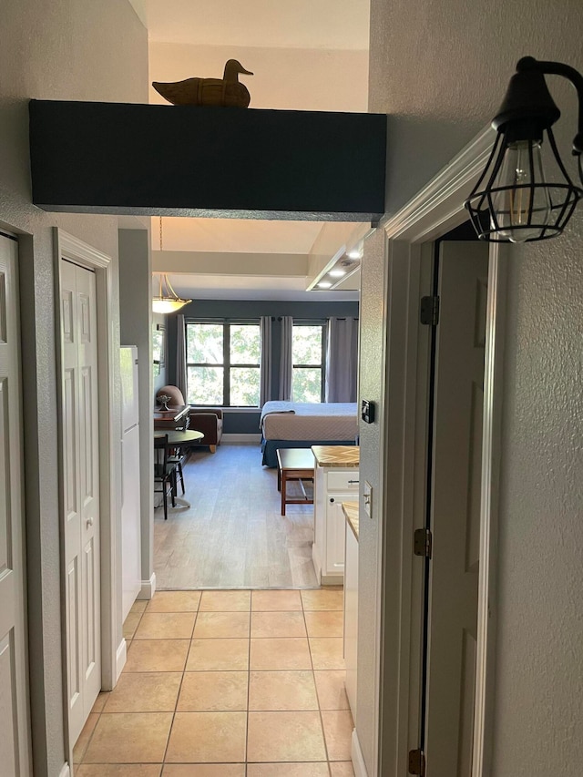 corridor with a notable chandelier and light wood-type flooring