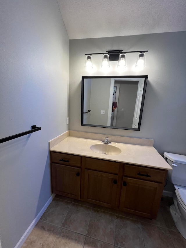 bathroom with vanity, tile patterned flooring, toilet, and a textured ceiling