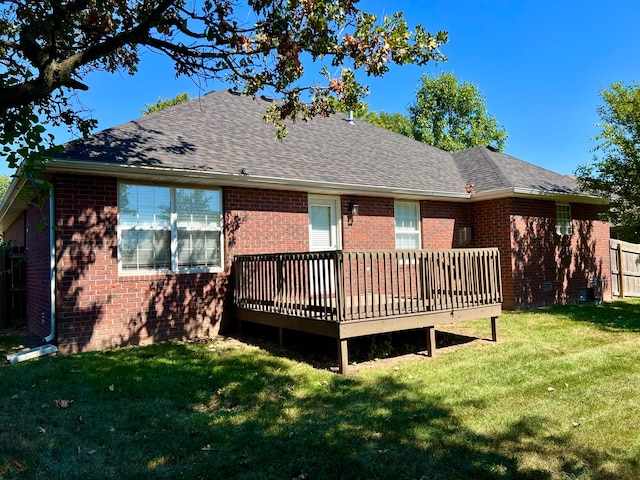 back of property with a deck and a lawn