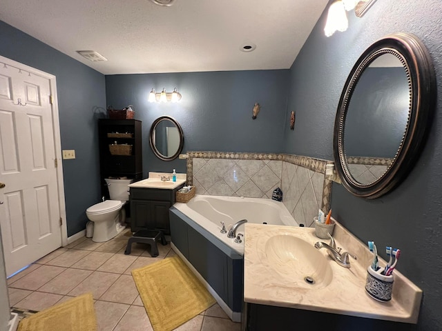 bathroom featuring vanity, a textured ceiling, a tub to relax in, tile patterned floors, and toilet