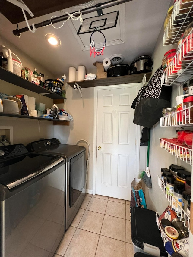 laundry area with washer and clothes dryer and light tile patterned flooring