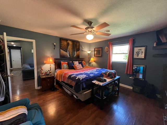 bedroom featuring ceiling fan, dark wood-type flooring, and a textured ceiling