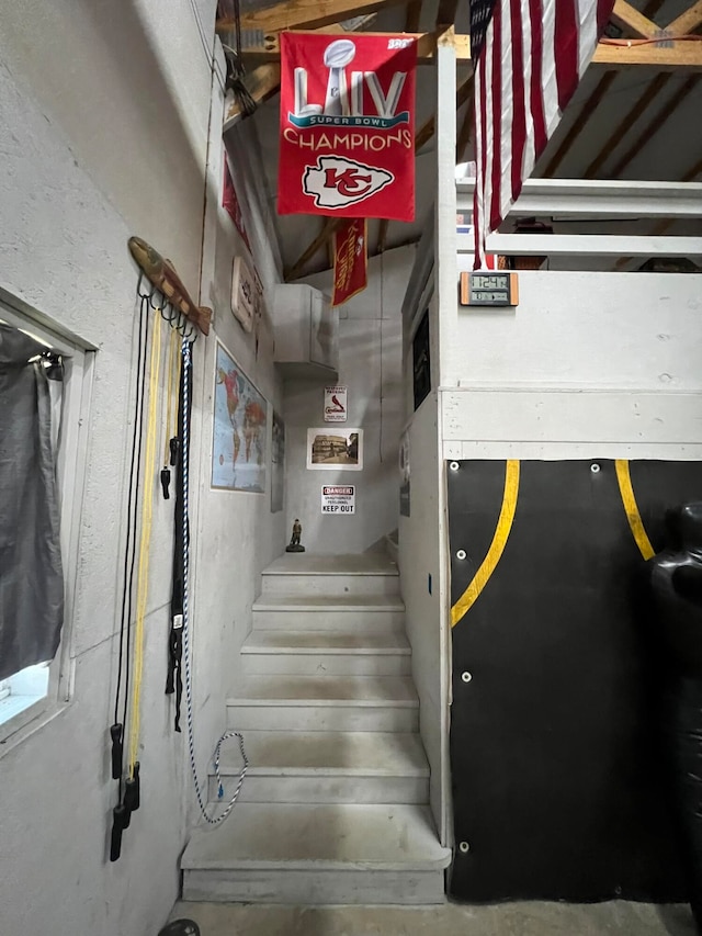 staircase featuring concrete floors