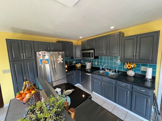 kitchen featuring light tile patterned flooring, appliances with stainless steel finishes, backsplash, and sink