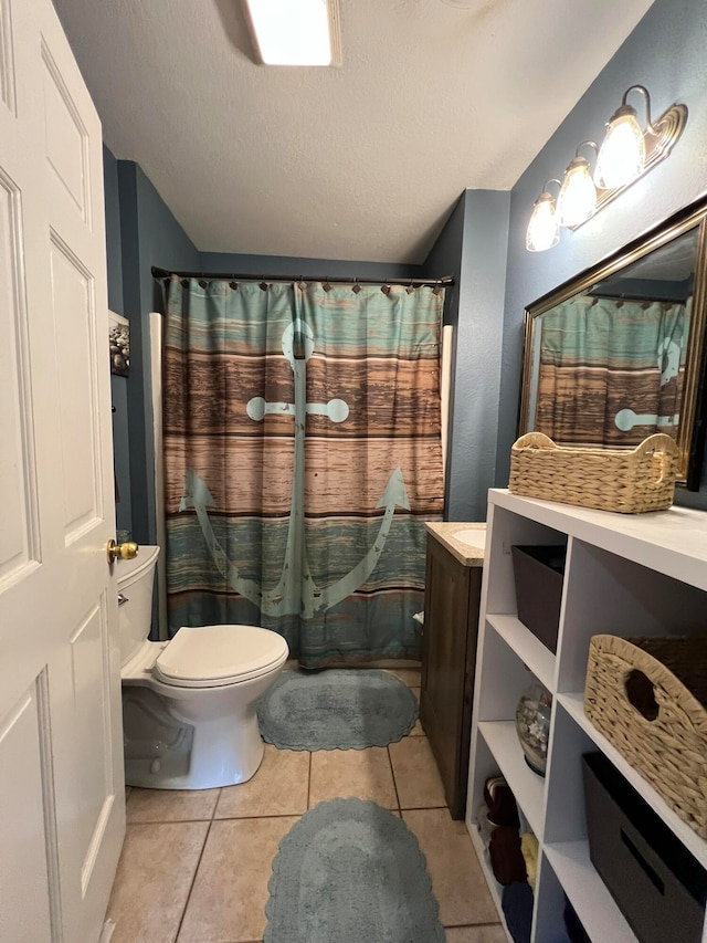 bathroom with vanity, toilet, a textured ceiling, and tile patterned floors