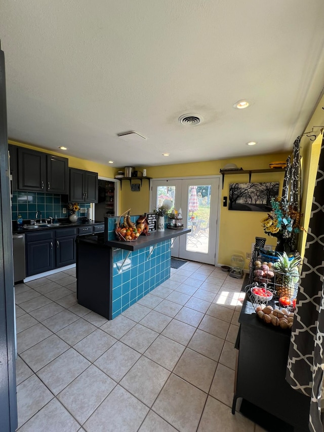 kitchen with tasteful backsplash, a breakfast bar area, a center island, dishwasher, and light tile patterned floors