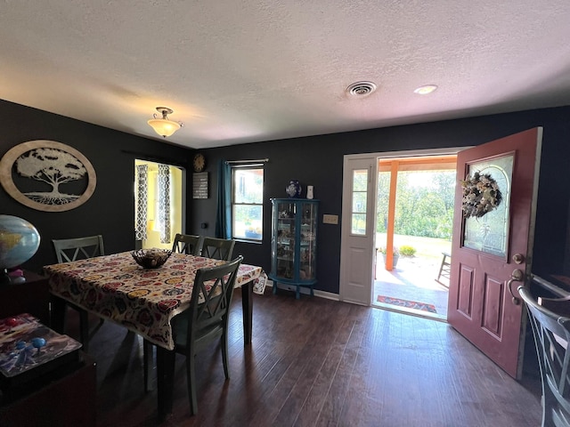 dining area with hardwood / wood-style floors and a textured ceiling