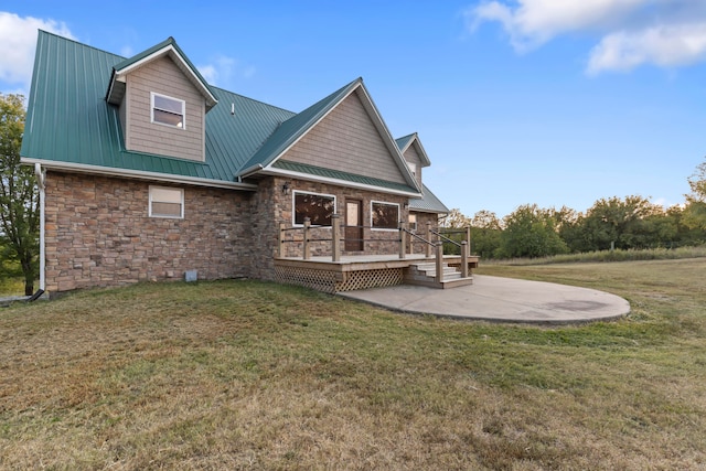 back of house with a wooden deck, a lawn, and a patio