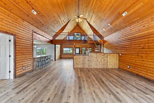 unfurnished living room featuring ceiling fan, wood ceiling, wood-type flooring, rustic walls, and high vaulted ceiling