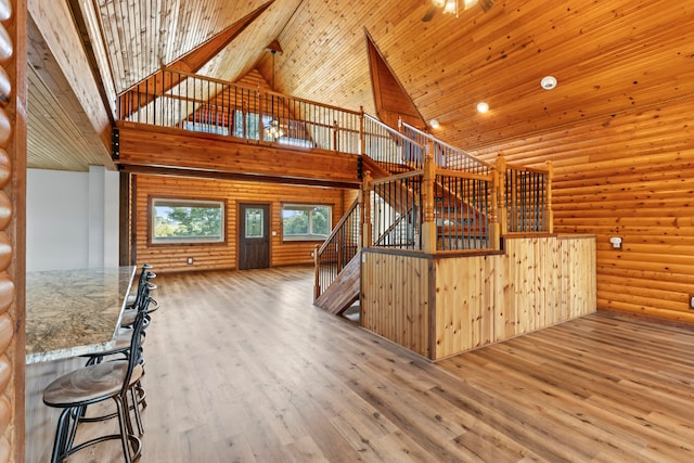 kitchen with stone countertops, hardwood / wood-style flooring, high vaulted ceiling, and wood ceiling