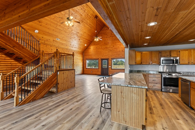 kitchen with stainless steel appliances, a center island, stone countertops, and light hardwood / wood-style flooring