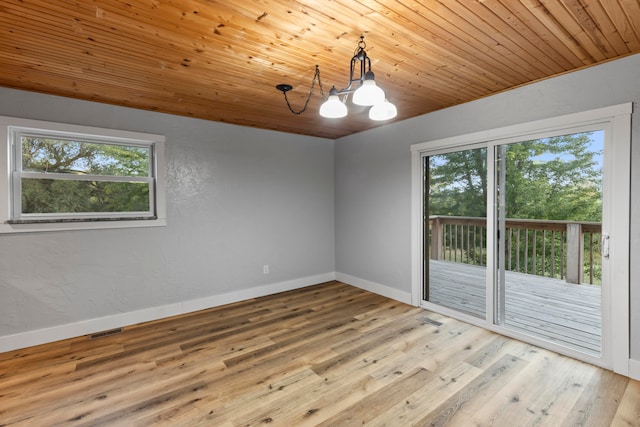 empty room with light hardwood / wood-style flooring, wood ceiling, and an inviting chandelier