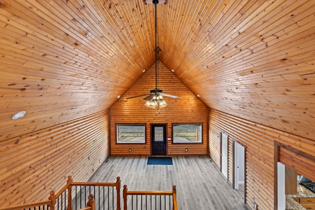 additional living space with ceiling fan, wood ceiling, wood walls, lofted ceiling, and light hardwood / wood-style floors