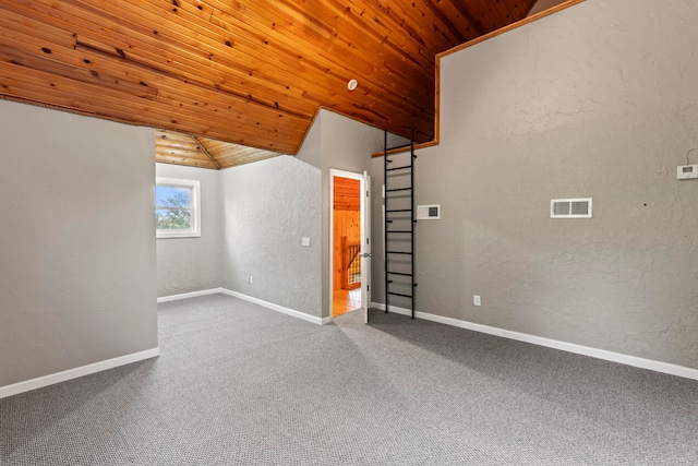 empty room featuring lofted ceiling, wood ceiling, and carpet