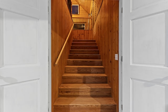 stairs featuring wood walls