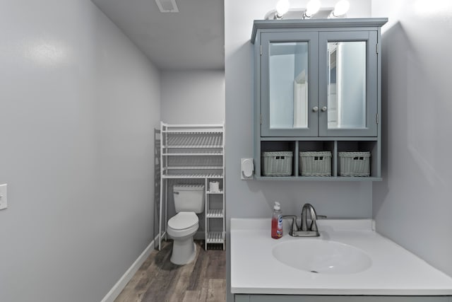 bathroom with hardwood / wood-style floors, vanity, and toilet