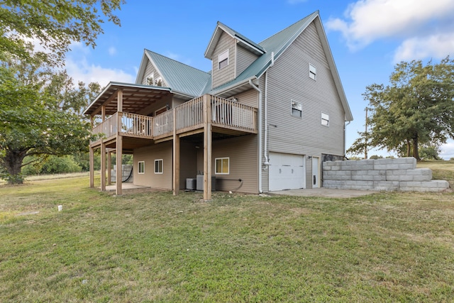 rear view of property with a yard, a deck, and a garage