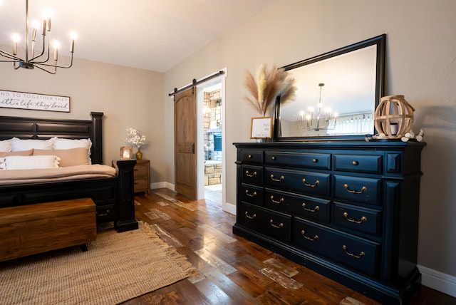 bedroom with a barn door and dark hardwood / wood-style flooring