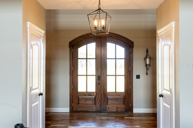 foyer entrance with french doors, a chandelier, and dark hardwood / wood-style flooring