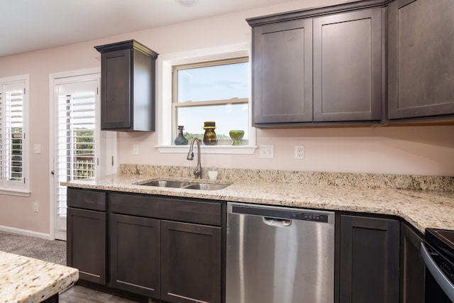 kitchen with appliances with stainless steel finishes, sink, dark brown cabinets, and light stone counters