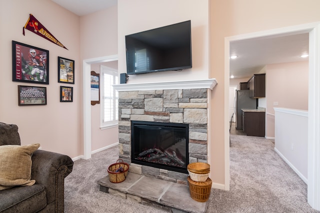 living room with a stone fireplace and light carpet