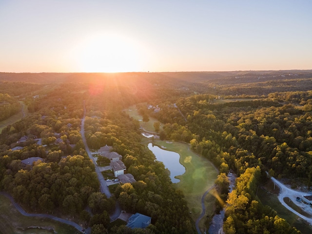 aerial view at dusk featuring a water view