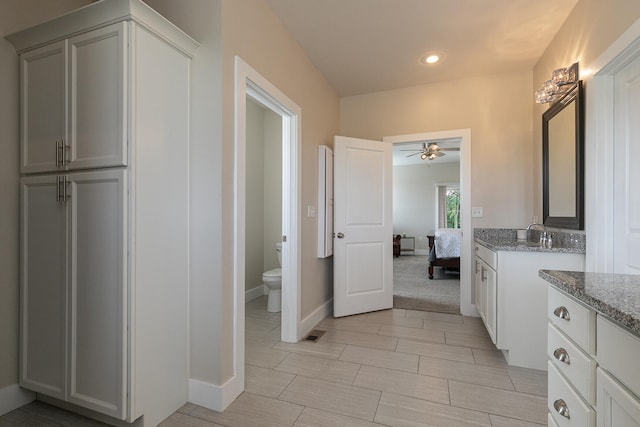 bathroom featuring ceiling fan, vanity, and toilet