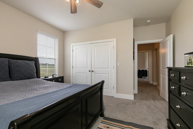 carpeted bedroom with ceiling fan and a closet