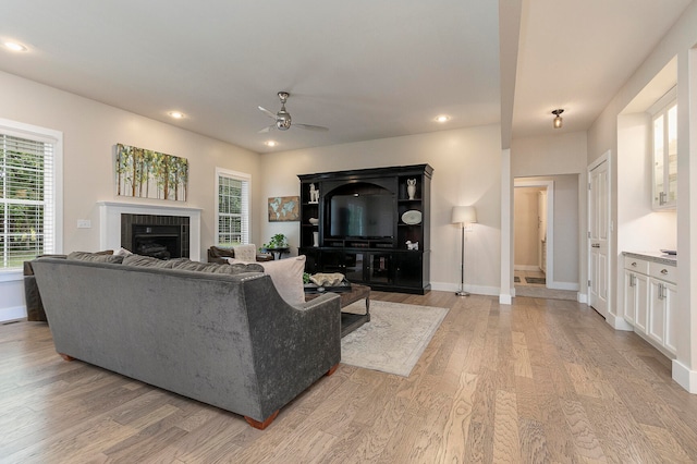 living room with light wood-type flooring and ceiling fan