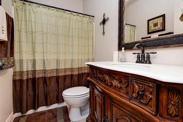 bathroom featuring toilet, vanity, and a shower with curtain