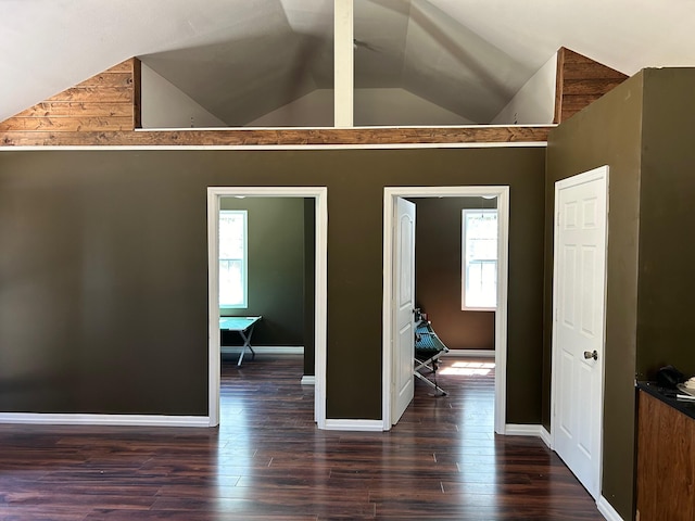 interior space with lofted ceiling with beams and dark wood-type flooring